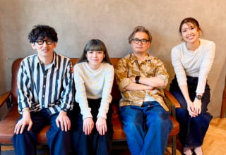 4名のスタッフが並んで座っているグループポートレート